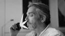 Black-and-white portrait of perfumer Antoine Maisondieu smelling a blotter.